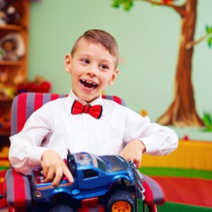 child with cerebral palsy in PA and happy playing with car toy