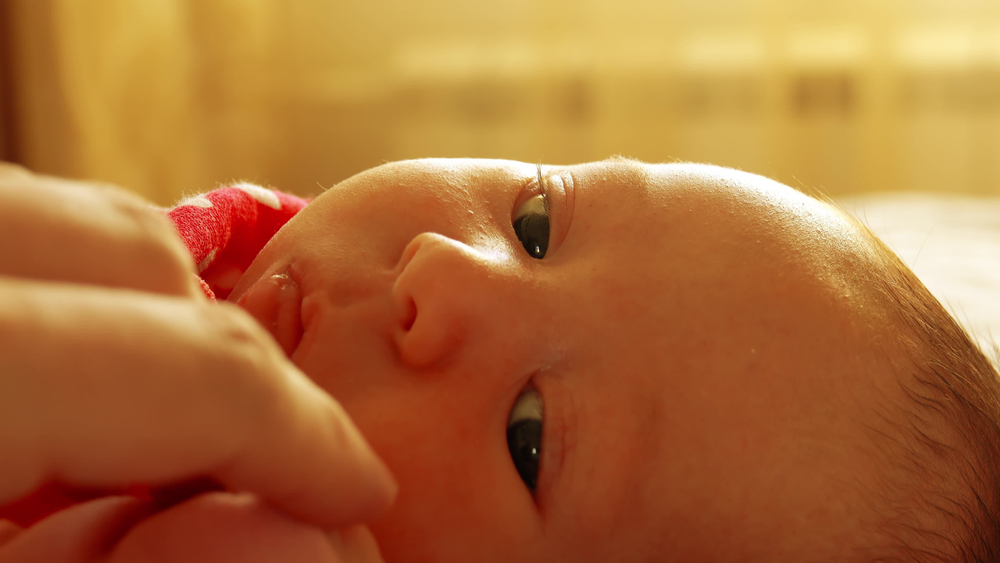 baby who has suffered a neonatal stroke looking at mom