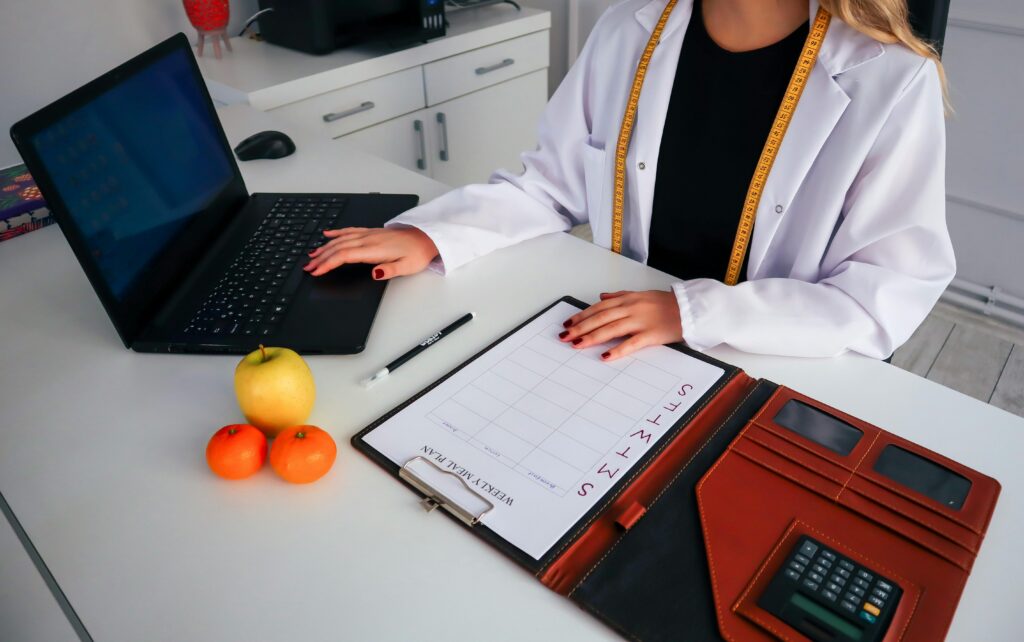 A doctor with dietary forms and fruit on her desk. In PKU mismanagement cases, even the slightest mistake can be held accountable.