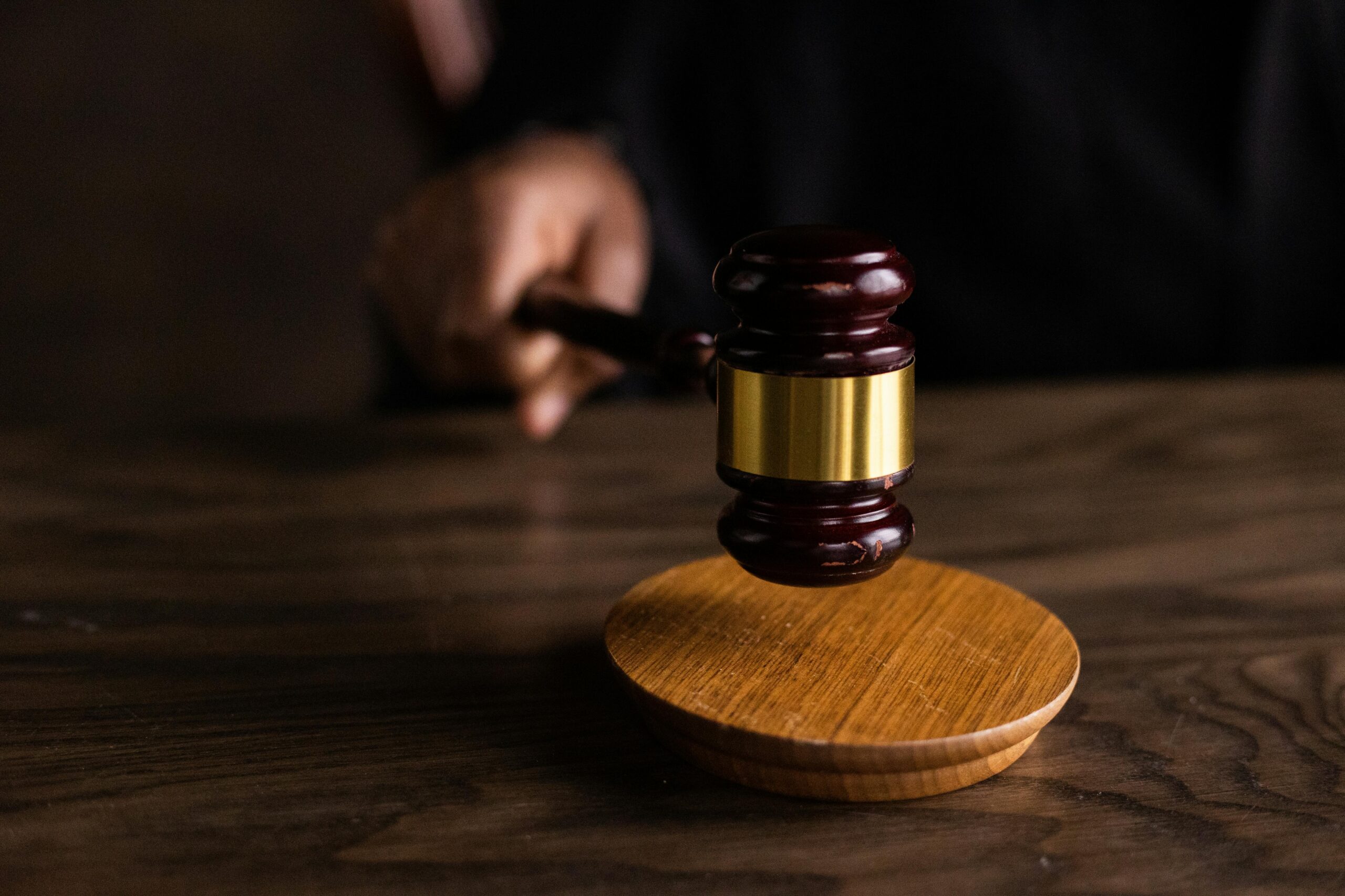 An image showing a hand holding a gavel. In a birth injury trial, it may take time before a verdict is reached.