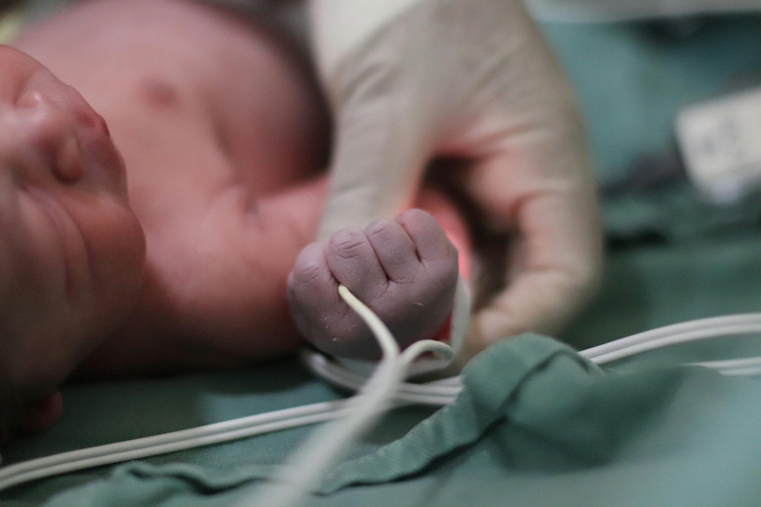 Close up on a newborn's tightly closed fist. In birth injury litigation, hospitals may defend their actions in many ways.