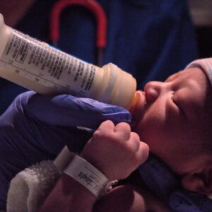 A feeding intolerance can quickly descend into NEC when left unchecked. Photo shows a newborn drinking formula.