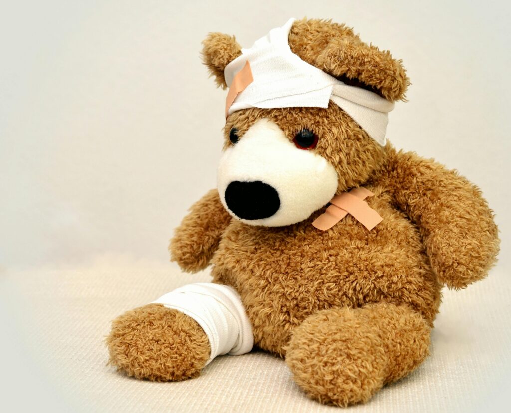 A teddy bear with bandages wrapped around its head, indicating a brain injury. When missed hypoglycemia occurs, such injuries may happen.