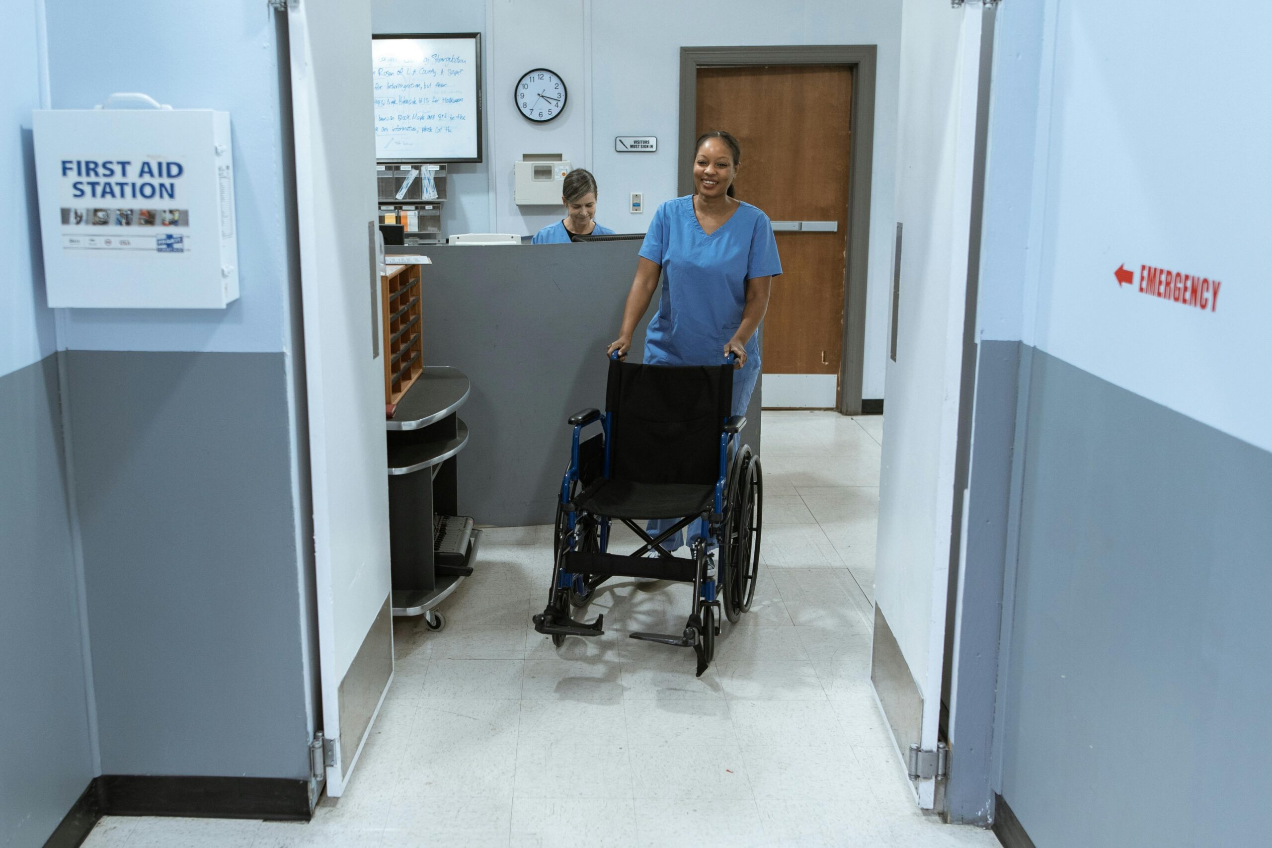 A nurse pushing a wheelchair through a hospital hallway. Medical handoffs are often routine, but when critical information isn't transferred with a patient, it can lead to mistakes.