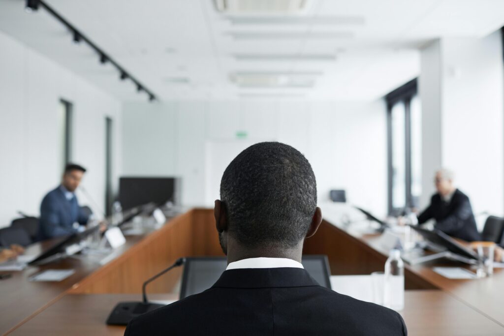 A conference room where two lawyers are discussing timing windows in front of a judge, who sits in the foreground.