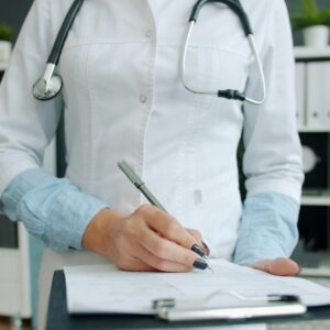 A doctor holding a clipboard with medical documents. Raw hospital data such as records can become evidence in negligence cases.