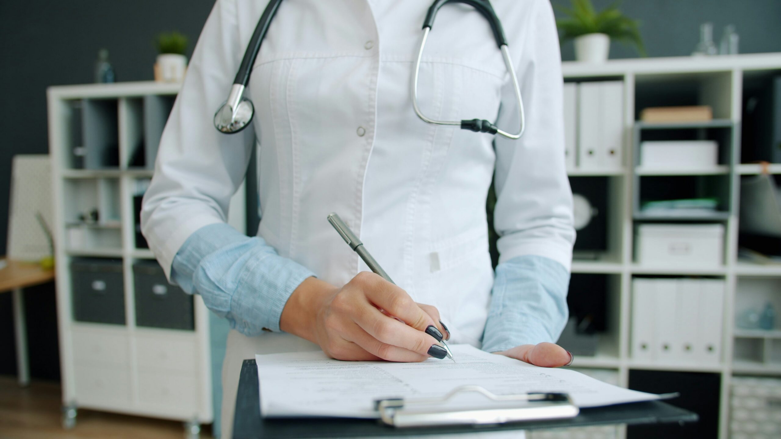 A doctor holding a clipboard with medical documents. Raw hospital data such as records can become evidence in negligence cases.