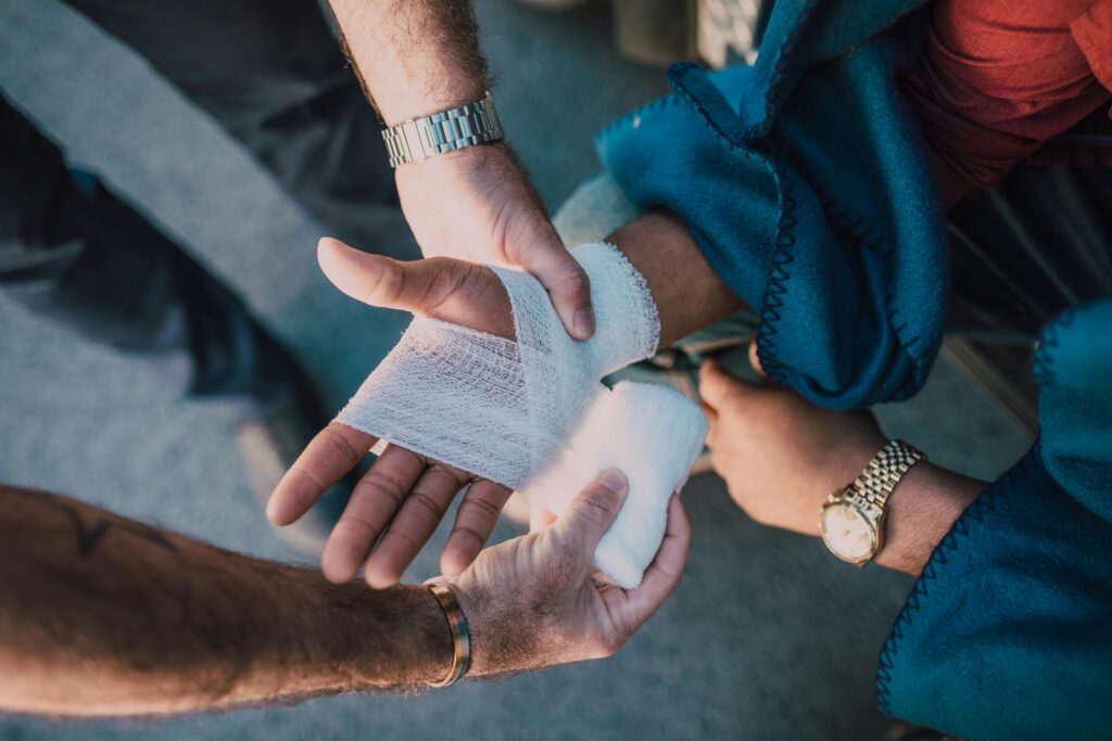 A person getting their hand wrapped with bandages after getting injured. In court, their injury will undergo human factor analysis to see if the harm caused was due to interaction and not something else.