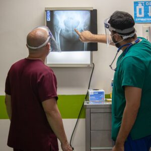 A specialist reviewing an injury. When patients have a delayed specialist consultation, an important window of opportunity for treatment may be missed, leading to injury.