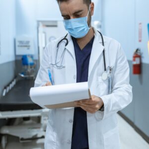 A doctor writing down late chart entries.