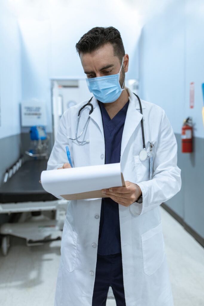 A doctor writing down late chart entries.
