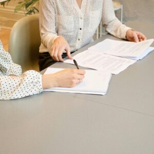 Two individuals looking over reports to find prior incidents to establish a pattern for a court case.