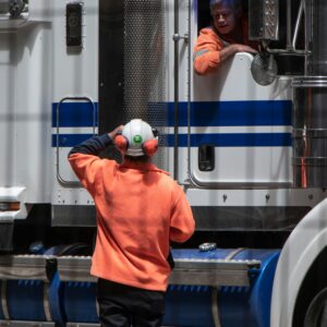 A truck driver and another employee preparing for work. The safety culture at a company is important in protecting drivers and others while on the road.