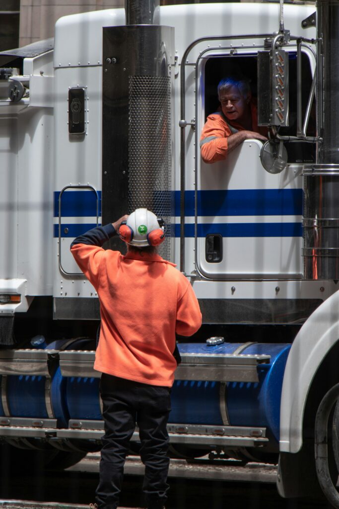 A truck driver and another employee preparing for work. The safety culture at a company is important in protecting drivers and others while on the road.