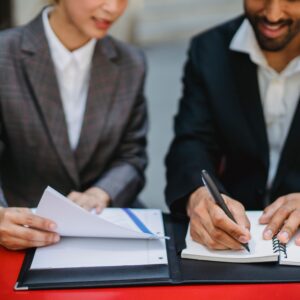 Two individuals looking at documents that ensure regulatory compliance.