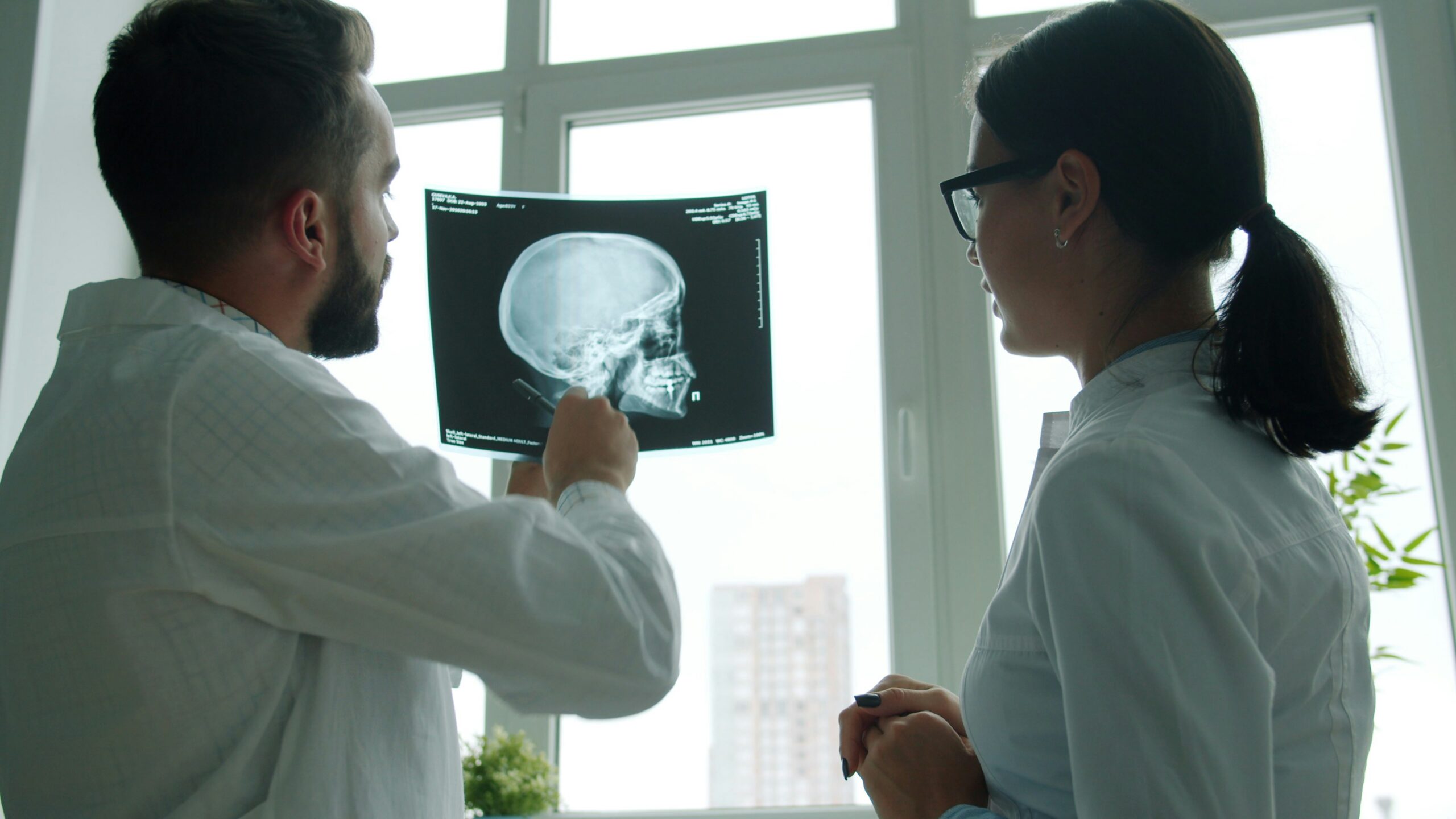 Two doctors looking at brain imaging. It does not show a skull fracture but something else.