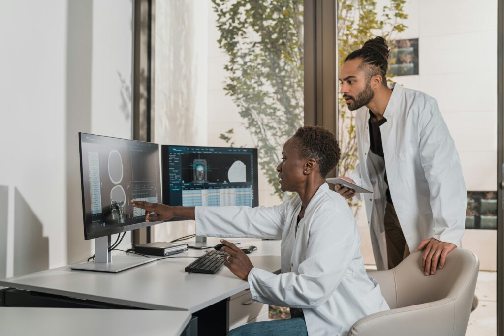 Two doctors looking at CT imaging. When the test is not done as soon as possible, injuries may develop unseen, leading to harm.