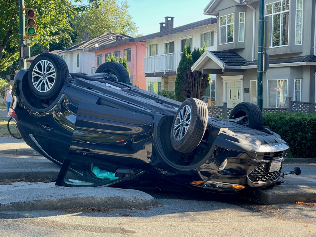 A vehicle that has rolled over during a truck collision and is heavily damaged.